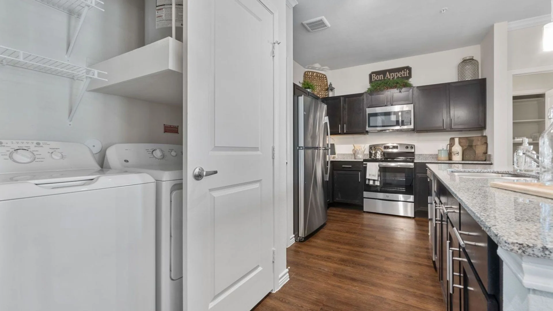 a kitchen with a washer and dryer in it at The Auberge of Burleson