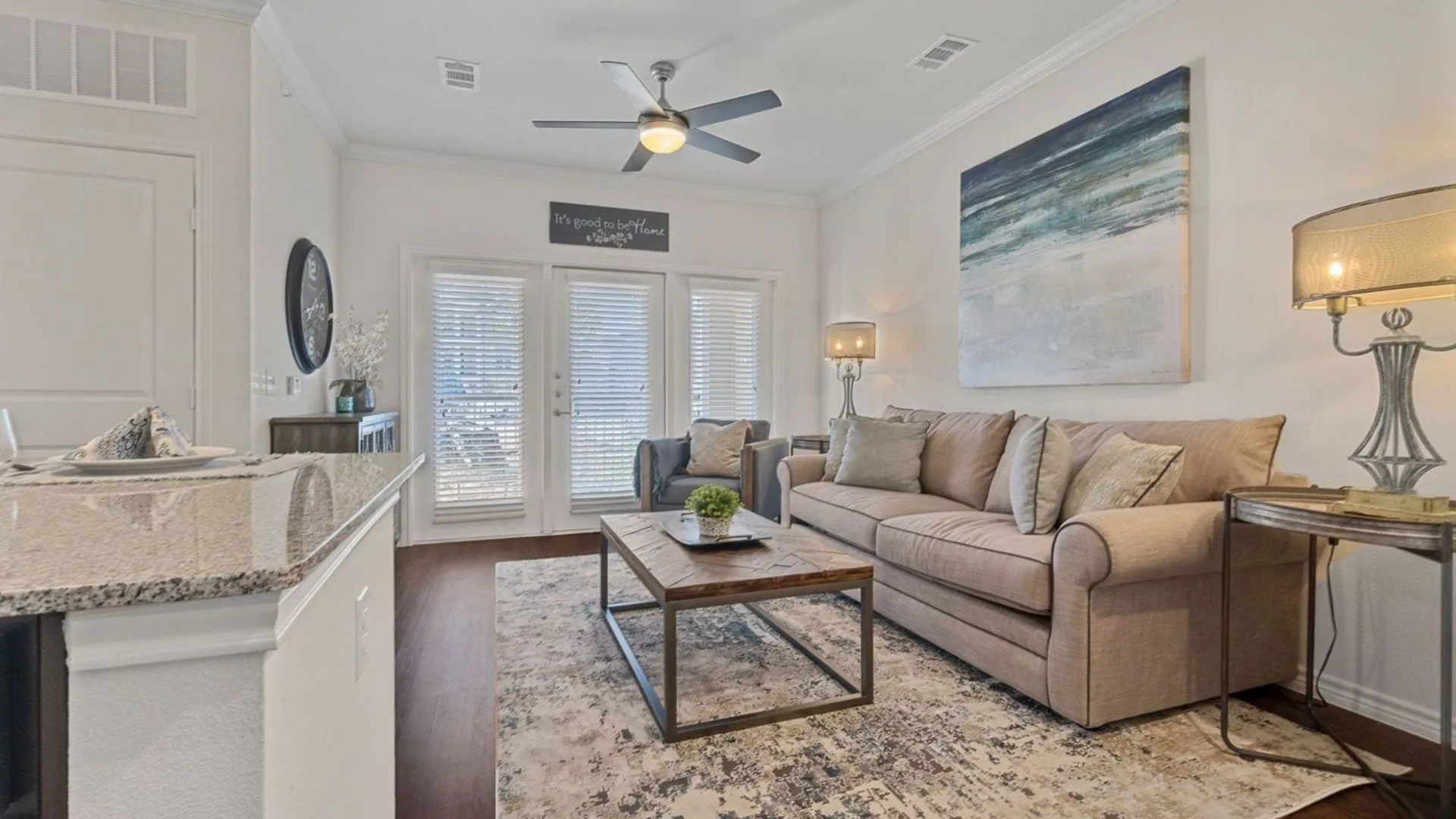 a living room with a ceiling fan and a couch at The Auberge of Burleson