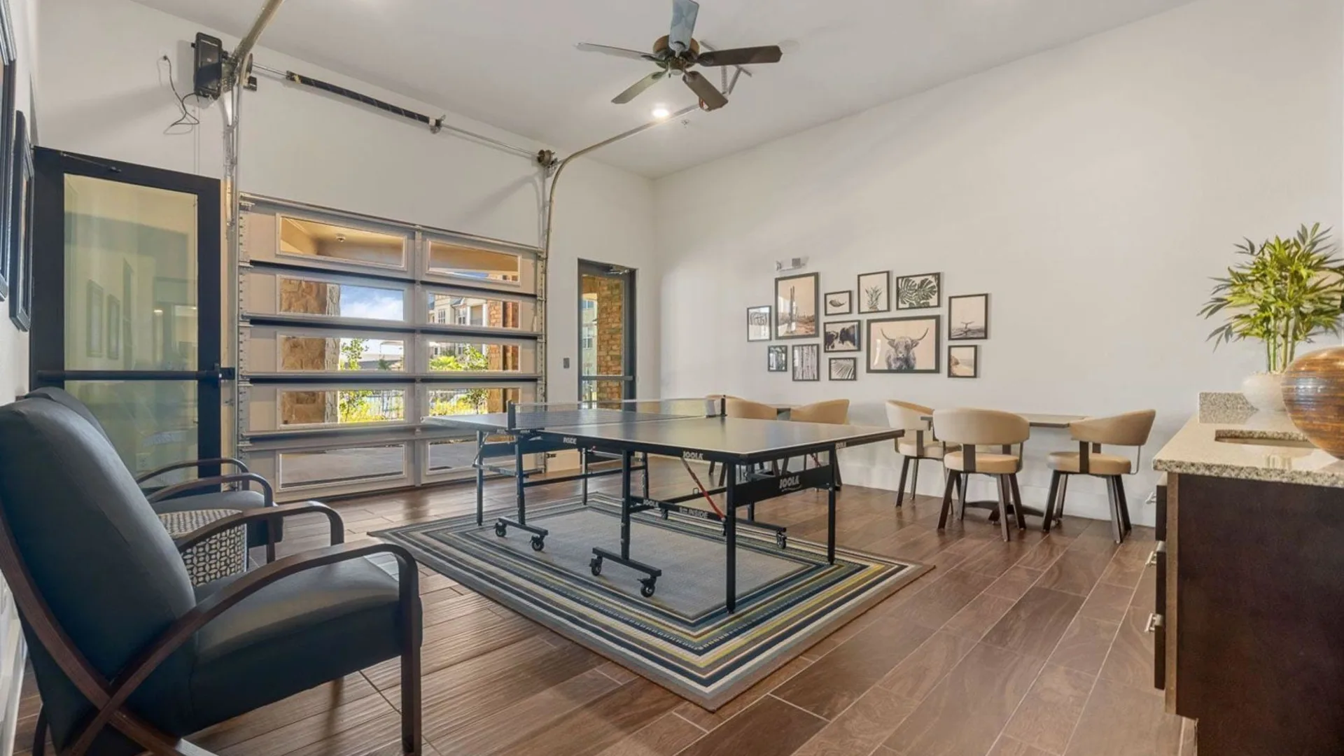 a ping pong table in a living room with a ceiling fan at The Auberge of Burleson