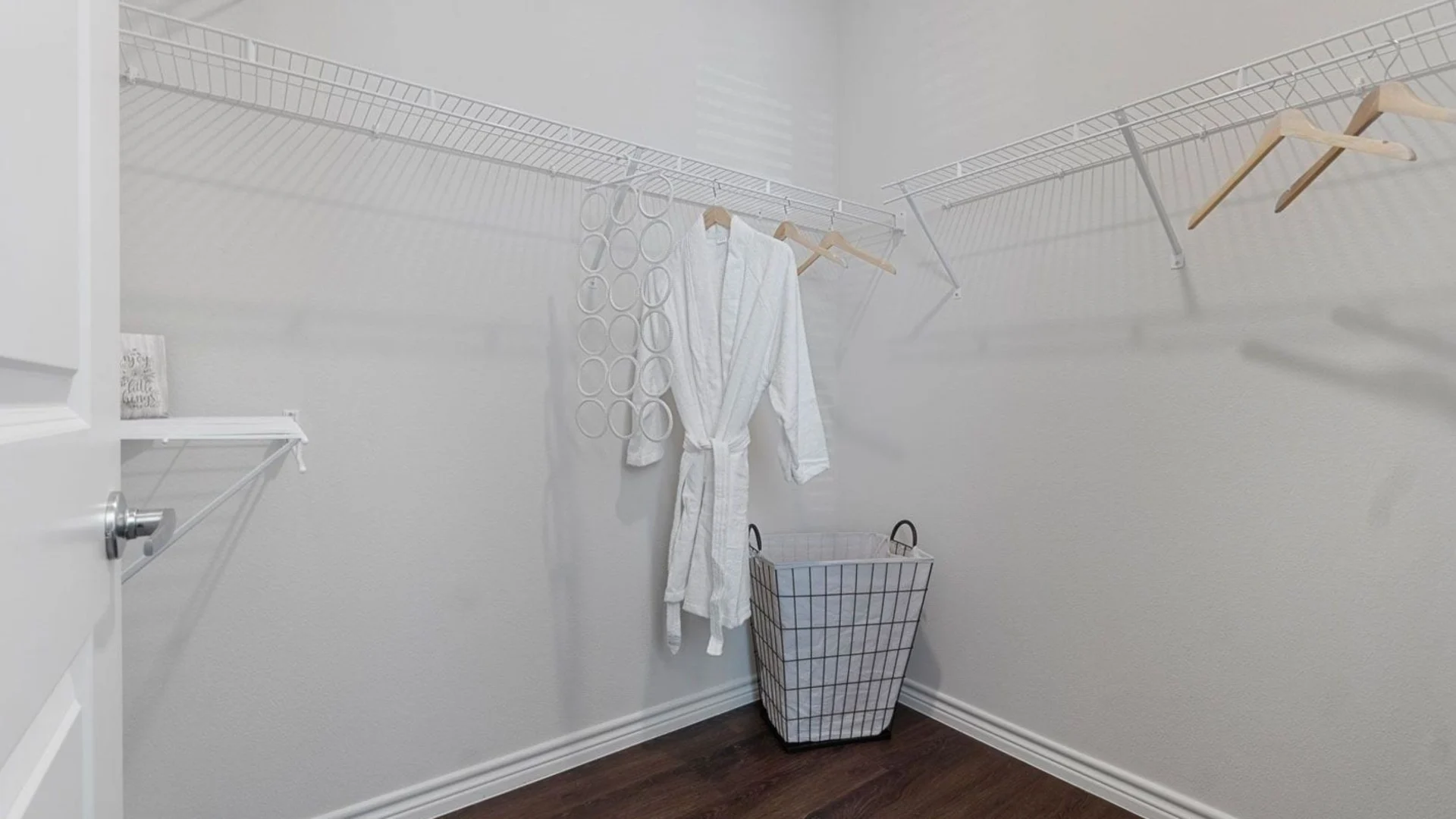 a closet with a white towel rack and clothes at The Auberge of Burleson