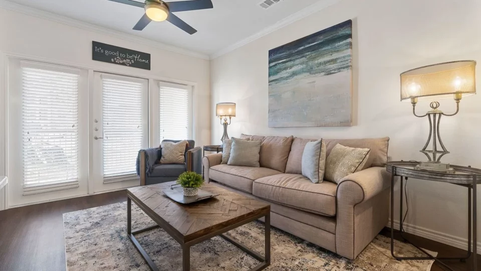 a living room with a ceiling fan and a couch at The Auberge of Burleson