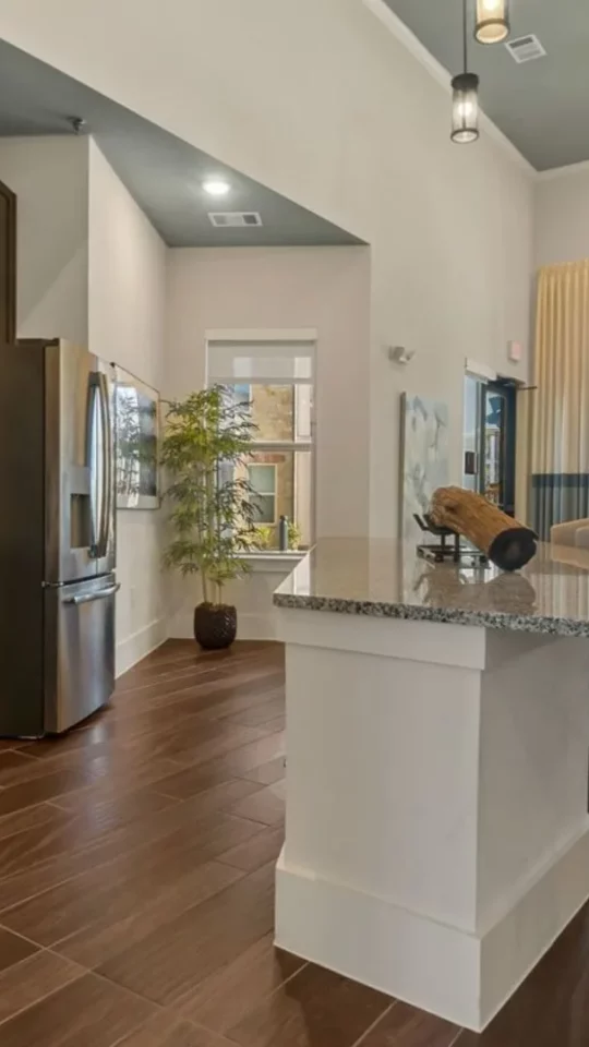 a kitchen with a large island and a large dining table at The Auberge of Burleson